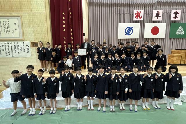 大隅ミート産業株式会社の小森浩一代表取締役が垂水小学校体育館ステージの緞帳幕を寄贈